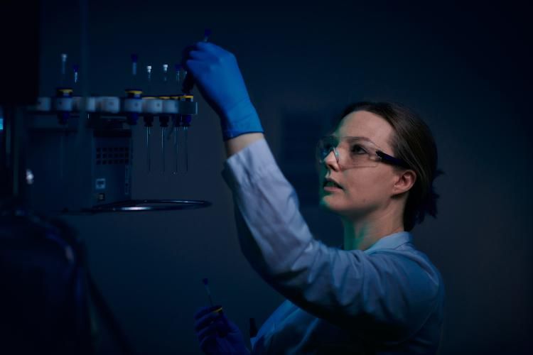 Female researcher examining vials